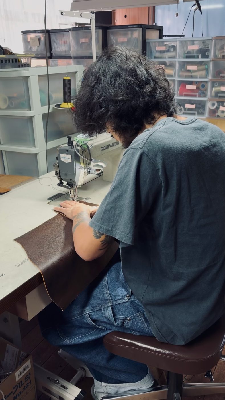 ミシンで革を縫製する職人